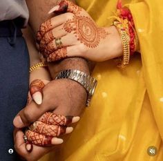 two people holding hands with henna on them