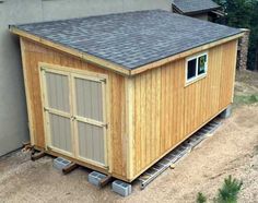 a small wooden shed sitting next to a building