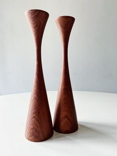 two wooden vases sitting on top of a white table