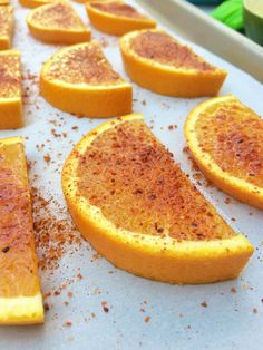 slices of oranges on a baking sheet with seasoning sprinkled on them