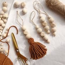 various crafting supplies are laid out on a white tablecloth with yarn, scissors and thread