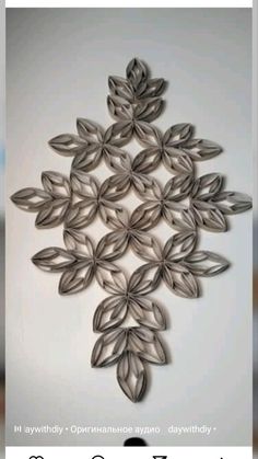 a white wall with some metal flowers on it