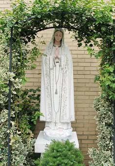 the statue is surrounded by greenery and shrubbery