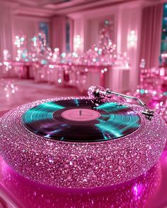 a record player sitting on top of a table covered in pink and blue glitters