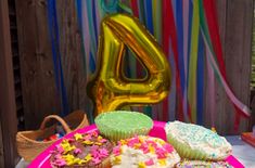 a pink plate topped with cupcakes covered in frosting and sprinkles