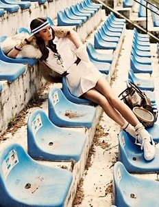 a woman sitting on bleachers with a tennis racket