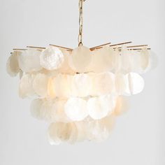 a chandelier made out of white rocks hanging from a chain