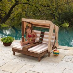 When the weather gets warm, your children will love to "chill" under the KidKraft Double Chaise Lounge's three-sided canopy. There's plenty of room for two friends to kick back and relax on a hot summer day, just like mom and dad. A pair of cup holders are perfect for cold drinks or even to hold snacks or bubble wands. There's even built in storage for sunglasses or toys. The high-quality, weather-resistant construction and sturdy canvas will keep this cute lounger looking good through all the seasons. Crafted of premium, recyclable materials for long-lasting play Recommended for ages 3+; each seat holds up to 85 lbs. 3-sided canopy provides shade and tie-back curtains provide window-style sides and privacy The hidden storage compartment is perfect for stashing shades or toys to keep them Outdoor Double Chaise, Kids Chaise, Double Chaise Lounge, Outside Furniture, Chaise Lounge Sofa, Chaise Lounger, Lounge Cushions, Double Chaise, Outdoor Chaise