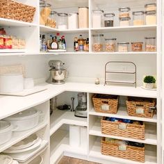 an organized pantry with white shelves and wicker baskets