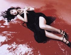 a woman laying on the ground wearing high heels