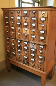 an old wooden filing cabinet with many drawers