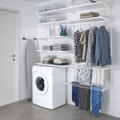 a washer and dryer in a room with white tile walls, open shelving