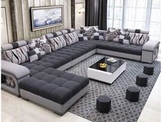 a living room filled with lots of furniture and pillows on top of a large rug