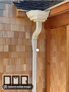 a white lamp post in front of a brick wall with wood paneling on it