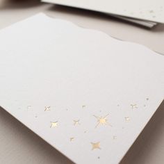 a white card with gold stars on it and some other cards in the back ground