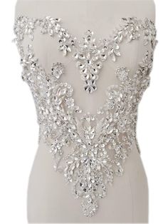 the back of a wedding dress with beading and crystal stones on it's chest