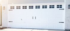 a white garage door is open in front of a house