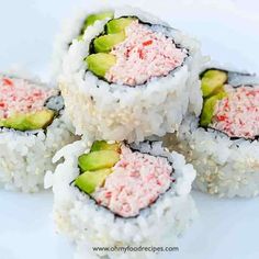 four sushi rolls are stacked on top of each other with pink and green sprinkles