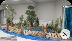 an indoor play area made out of pallets and wooden planks with plants growing on them