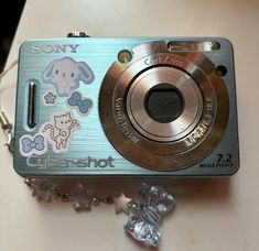 a digital camera sitting on top of a table next to a keychain and chain