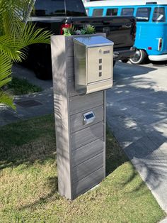 a mailbox with a plant in it on the side of the road next to a blue van