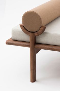 a close up of a wooden bench with a pillow on it's back end