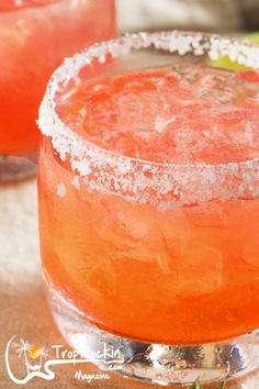 a close up of a drink in a glass with sugar on the rim and garnish