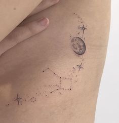 a woman's stomach with stars and a clock tattoo on her left side ribcage