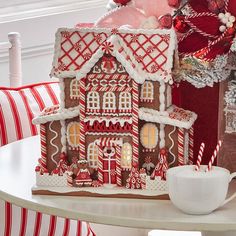 a gingerbread house decorated with icing and candy canes sits on a table