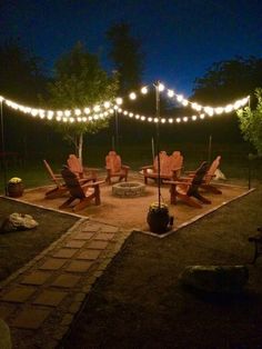 a fire pit surrounded by lawn chairs and string lights