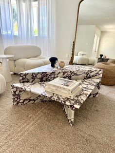 a living room filled with furniture and a large mirror on the wall above it's coffee table