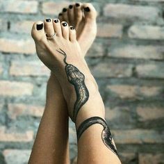 a woman's legs with black and white tattoos on them