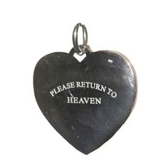 a black heart shaped pendant with the words please return to heaven written in white on it