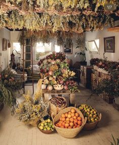 a room filled with lots of different types of flowers and fruit in baskets on the floor