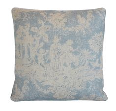 a blue and white pillow with an intricate design on the front, in shades of gray