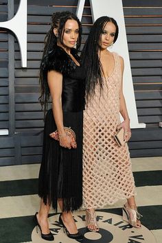 two women standing next to each other on a carpet