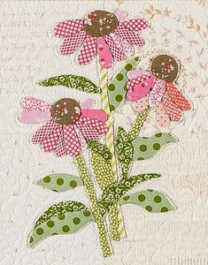 a close up of a flower on a piece of paper with polka dots and green leaves