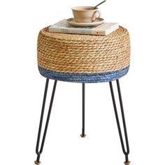 a table with a basket on top and a cup sitting on top of the base