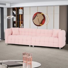 a living room with a pink couch and two glasses on the coffee table in front of it