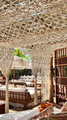 an outdoor seating area with lots of wicker furniture and canopy over the seating area