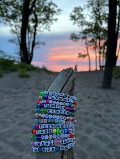 a wooden post with several bracelets on top of it in front of some trees