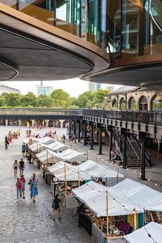 many tents are set up in the middle of an open air area with people walking around