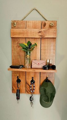 a wooden shelf with several key hooks and a hat hanging from it's side