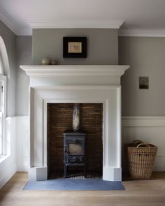 an image of a living room with a fire place on the wall and a basket next to it