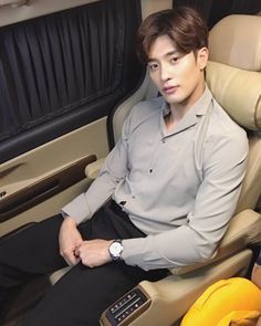 a young man sitting in the back seat of an airplane with his hand on his hip