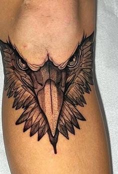 an eagle head tattoo on the side of a man's right leg with black ink