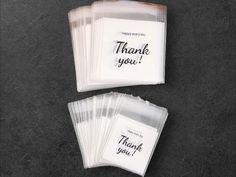 thank you notes in plastic bags on top of a black table with the words thank you written on them