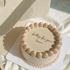 there is a cake in the box on the table with it's name written