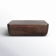 a square metal object sitting on top of a white surface with no one around it