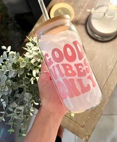 a person holding a glass with the words good vibes only on it and a straw in their hand